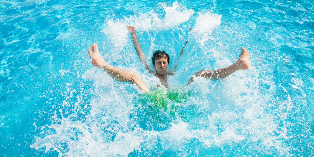 person splashing into swimming pool